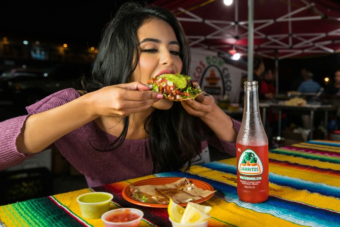 Eine Frau isst in einem Restaurant gierig mexikanisches Essen.