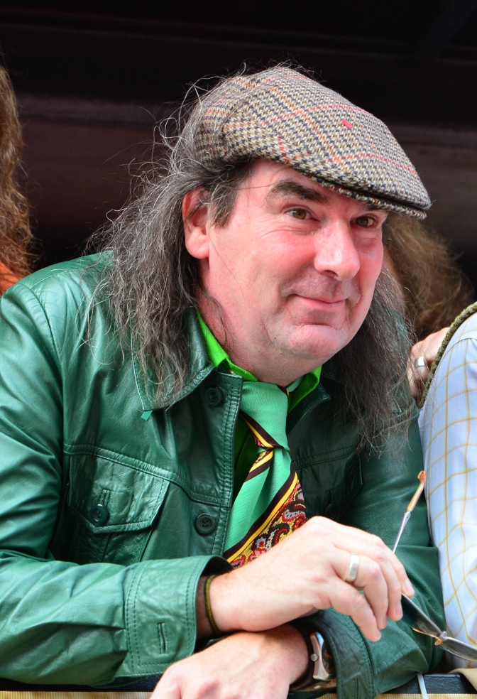 Guildo Horn in einer grünen Lederjacke mit Schiebermütze und Krawatte.