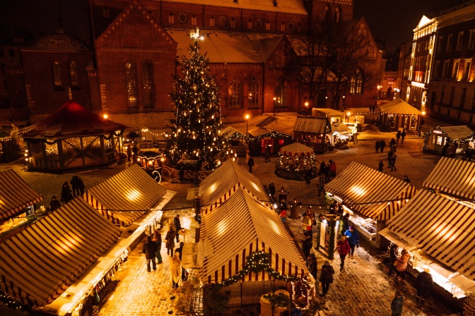Weihnachtsmarktstände mit etwas Schnee auf den Dächern, von oben fotografiert.