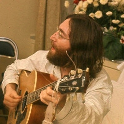 John Lennon spielt Gitarre und singt