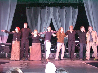 8 Mitglieder der Kelly Family zusammen auf der Bühne. Sie haben alle lange, glatte Haare.