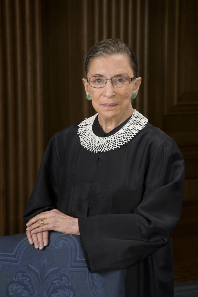 Ruth Bader Ginsburg in Richterrobe und mit einem weißen Perlenkragen.