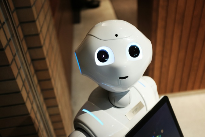 Ein weißer Roboter mit blau leuchtenden Augen, die direkt in die Kamera schauen.