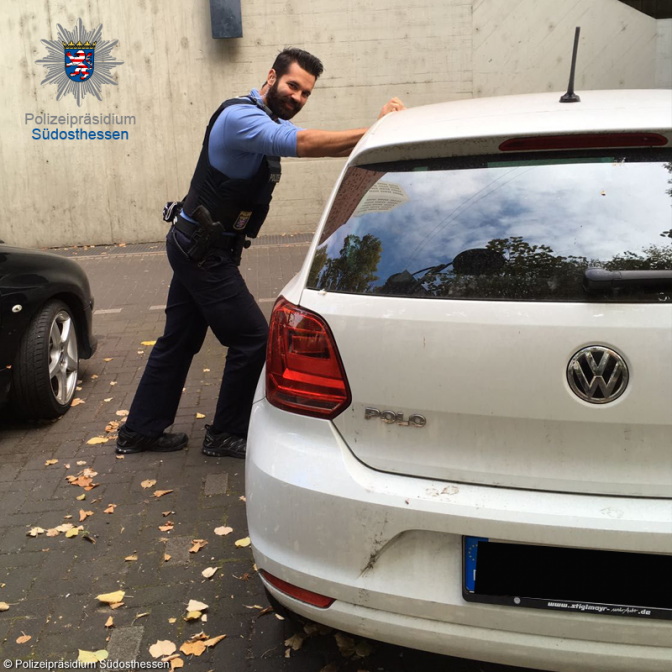 Ein Polizist schaukelt ein Baby im verschlossenen Auto