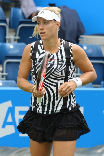 Angelique Kerber in einem schwarz-weißen Tennisdress auf dem Platz. Sie hält einen Tennisschläger in der Hand.