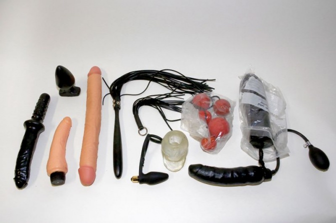 Verschiedene Dildos, eine Peitsche und andere Sexspielzeuge