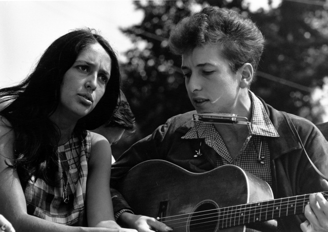 Joan Baez und Bob Dylan machen zusammen Musik: Sie singt, er spielt Mundharmonika.