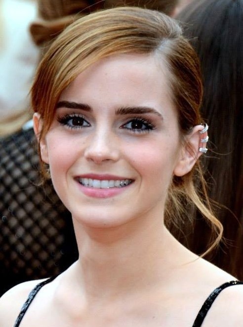 Emma Watson mit hochgesteckten Haaren in einem dunklen Träger-Top
