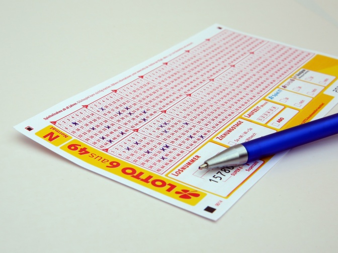 Ein ausgefüllter Lottoschein, daneben liegt ein Kugelschreiber