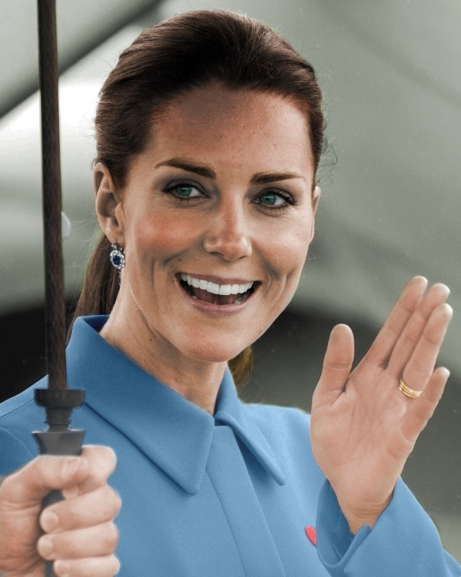 Herzogin Kate läuft unter einem Schirm und winkt.