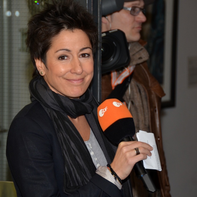 Dunja Hayali lächelt und hält ein Mikrophon mit dem Logo des ZDF in der Hand