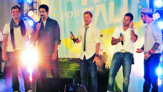 Die Backstreet Boys auf der Bühne, im Hintergrund farbige Scheinwerfer.