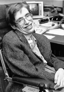 Stephen Hawking sitzt im Rollstuhl vor einem Schreibtisch