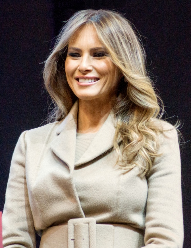 Melania Trump, lächelnd in einem hellen Kostüm