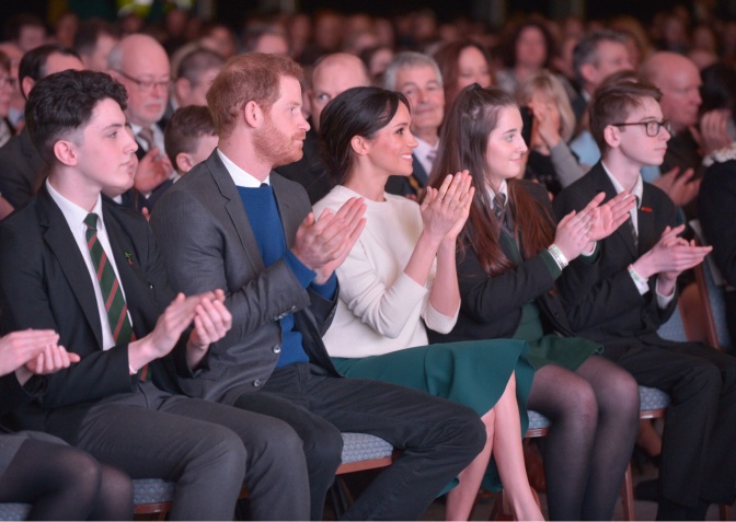 Prinz Harry und Prinzessin Meghan sitzen im Publikum und applaudieren