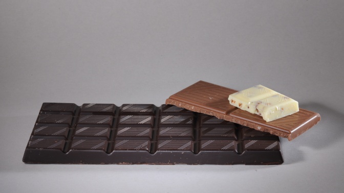 3 Tafeln Schokolade in verschiedenen Größen liegen aufeinander: Biiterschokolade, Vollmilchschokolade und weiße Schokolade.