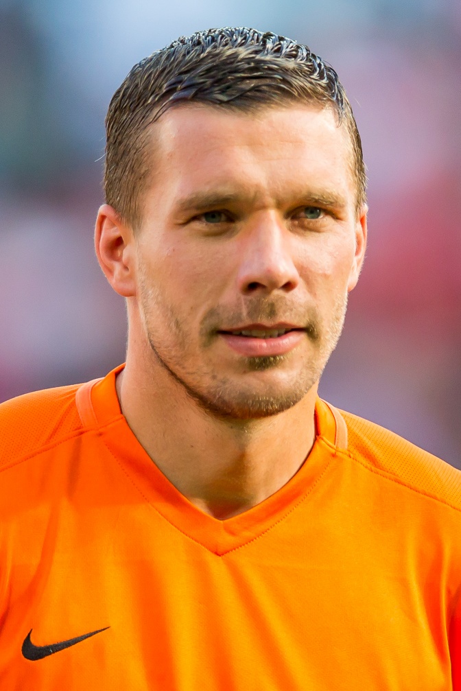 Lukas Podolski in einem orangefarbenen Fußballtrikot