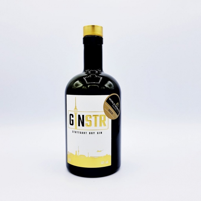 Eine Flasche GINSTR Gin: die Flasche ist aus braunem Glas, bauchig und mit schmalem Hals. Am Etikett ist ein goldenes Emblem für die Prämierung als bester Gin 2018.