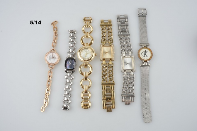 Mehrere gestohlene goldene und silberne Uhren liegen nebeneinander. Sie sind mit Schildchen gekennzeichnet.