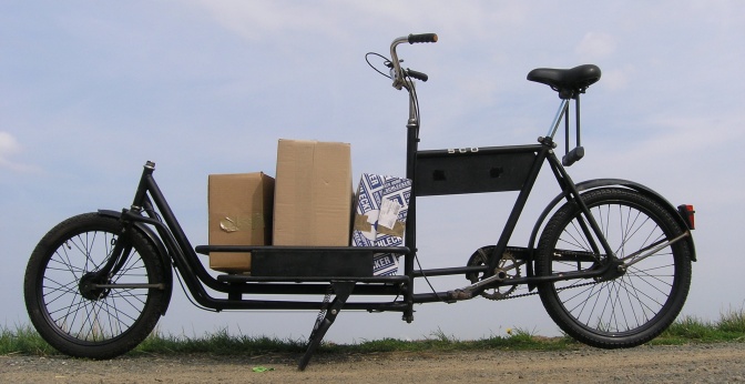 Ein Lasten-Fahrrad, beladen mit 2 großen Pappkartons