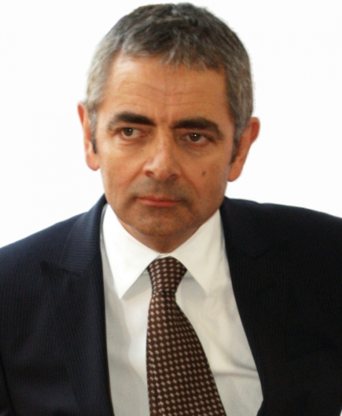 Rowan Atkinson in Anzug und Krawatte. Er hat kurze, graue Haare.