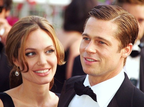 Angelina Jolie und Brad Pitt in Abendgarderobe. Beide tragen schwarz und lächeln.