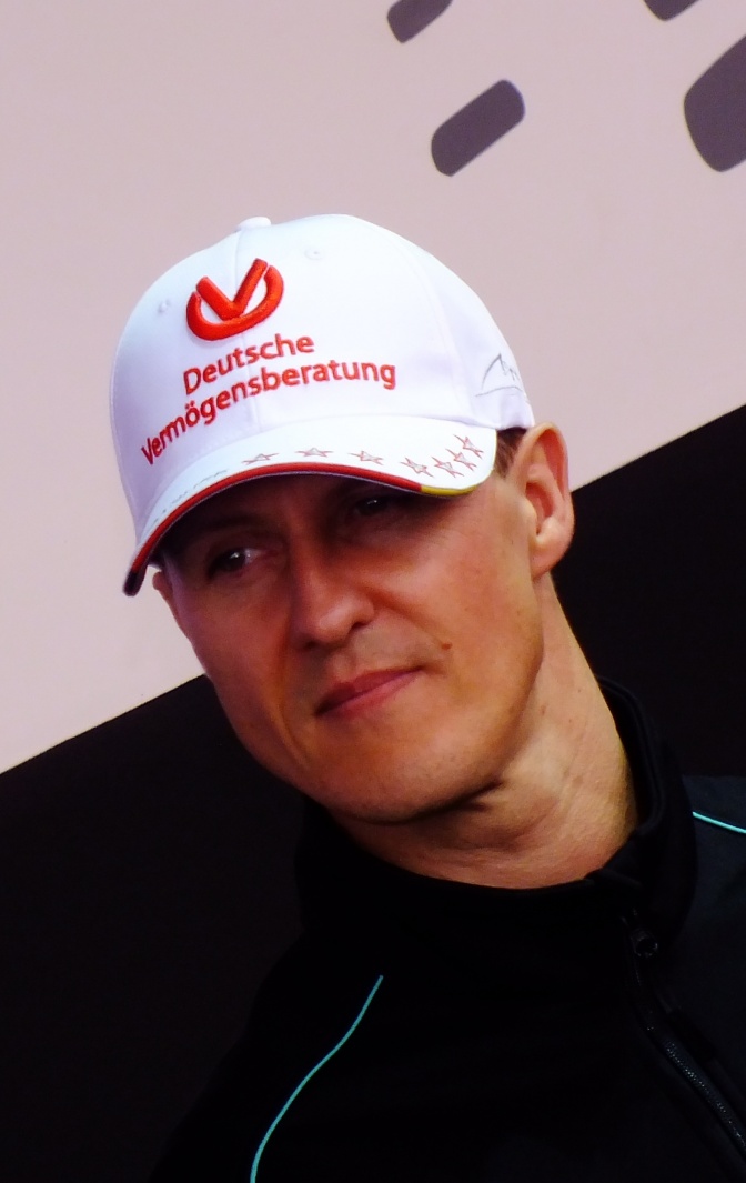 Michael Schumacher mit einer weißen Schirmmütze, darauf steht Werbung für die Deutsche Vermögensberatung.