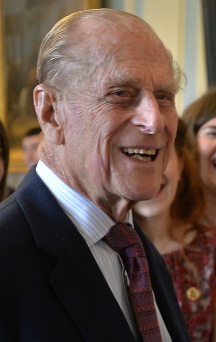 Prinz Philip in Anzug und Krawatte. Er ist im Profil fotografiert und lächelt.