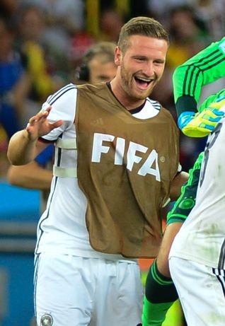 Shkodran Mustafi jubelt. Er steht auf dem Spielfeld und trägt ein Trikot mit der Aufschrift FIFA.