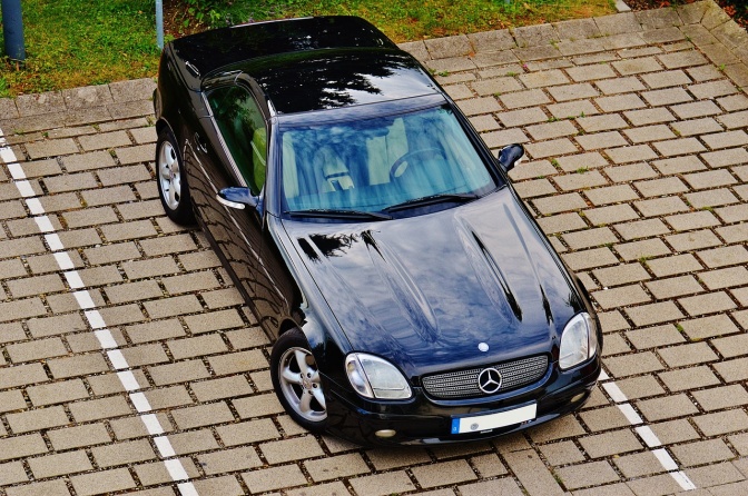Eine schwarze, geparkte Limousine, die zwischen zwei Markierungsstreifen geparkt ist.