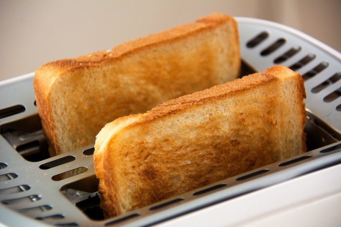 2 Toastscheiben stecken getoastet in einem Toaster.