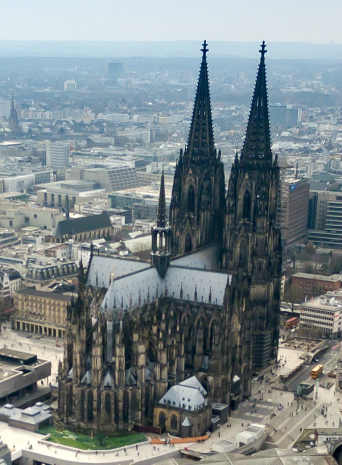 Der Kölner Dom aus der Luft fotografiert. Er hat 2 Kirchtürme mit spitzen Dächern.