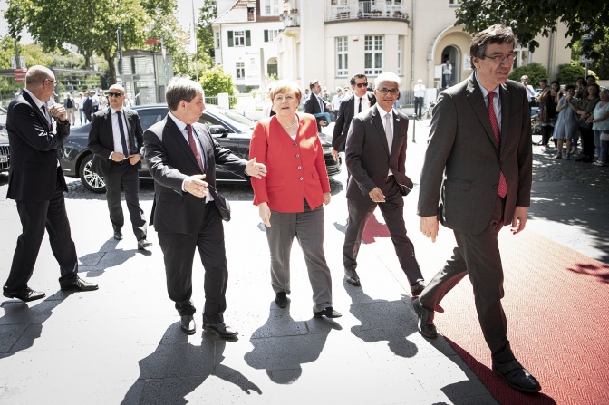 Angela Merkel kommt am Haus der Geschichte an und geht neben dem roten Teppich ins Gebäude.