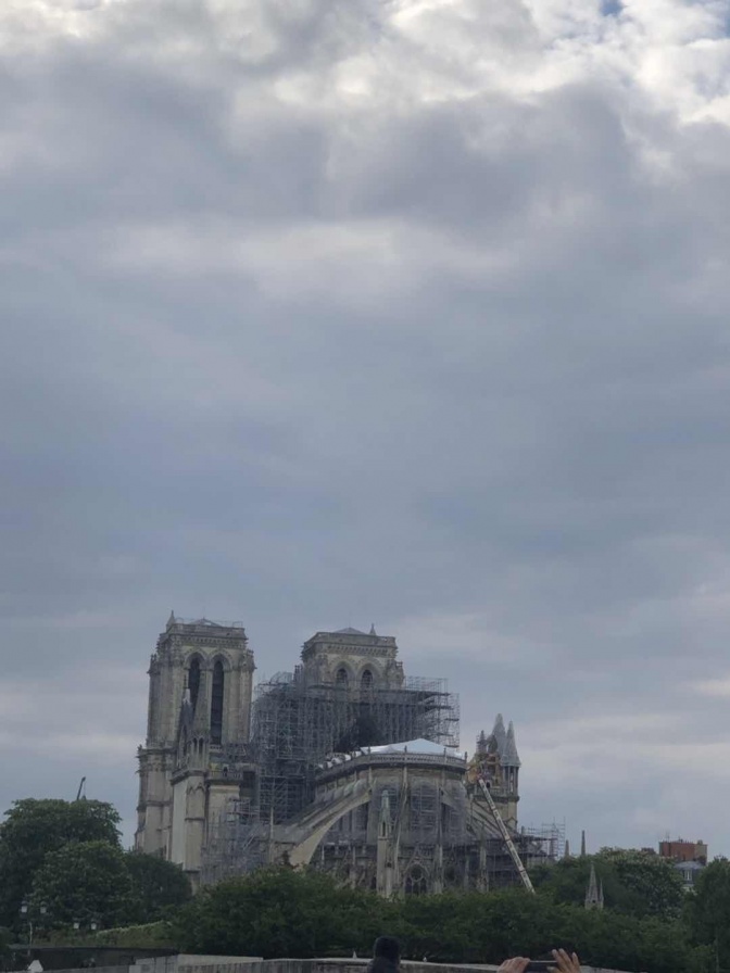 Notre Dame in Gerüsten vor bewölktem Himmel.