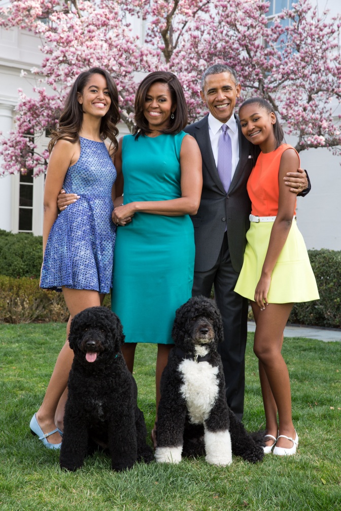 Familie Obama mit ihren beiden Hunden vor blühenden Bäumen