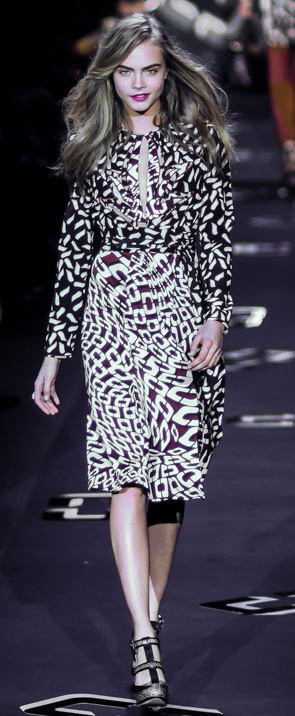 Cara Delevingne als Model auf dem Laufsteg. Sie trägt ein Kleid mit Zebramuster.