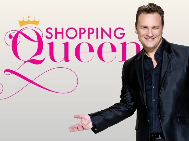 Guido Maria Kretschmer steht im schwarzen Anzug vor dem Schriftzug der Sendung Shopping Queen