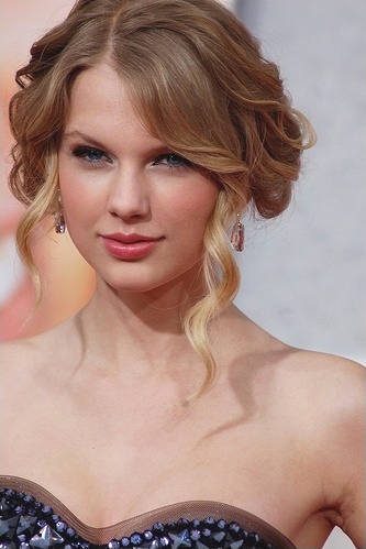 Taylor Swift mit hochgesteckten Haaren und im schulterfreien Kleid