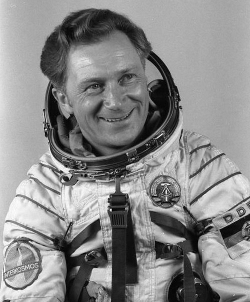 Ein schwarz-weiß-Foto eines lächelnden Mannes im Weltraumanzug