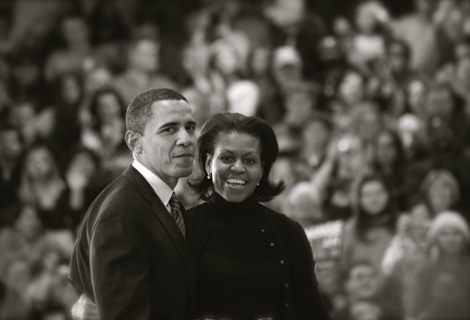 Michelle und Barack Obama. stehen Arm in Arm vor einer Menschenmenge.