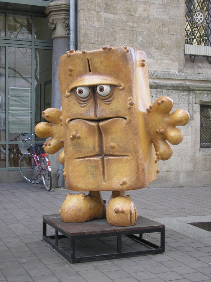 Eine überlebensgroße Statue von Bernd dem Brot auf einem Sockel aus Metall