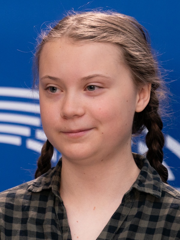 Greta Thunberg mit geflochtenen Zöpfen und in einer karierten Bluse.
