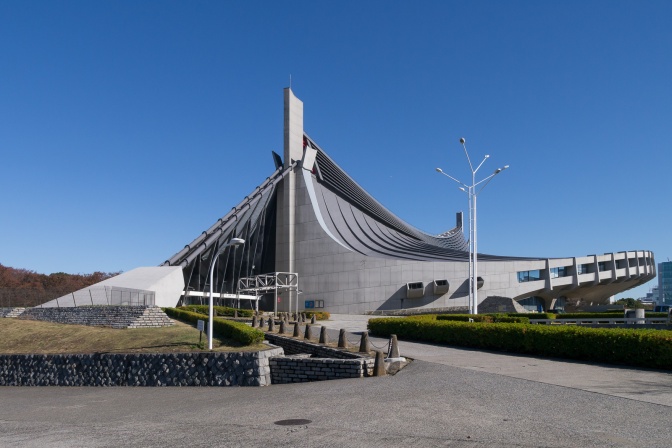 Ein futuristisches Gebäude mit viel Metall und spitzem, tütenförmigem Dach