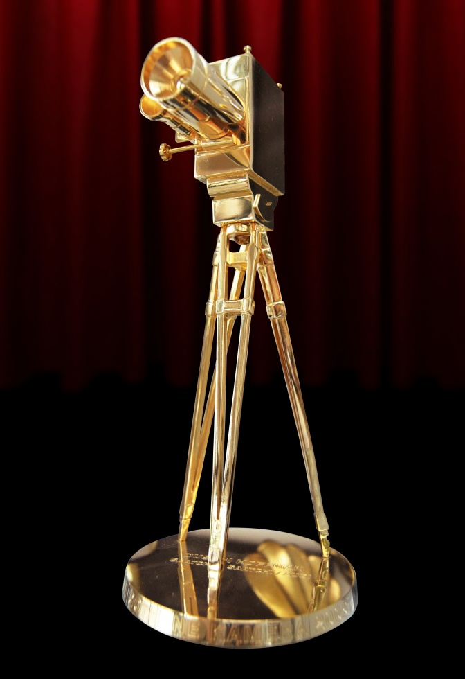Eine goldene Kamera auf einem dreibeinigen Stativ