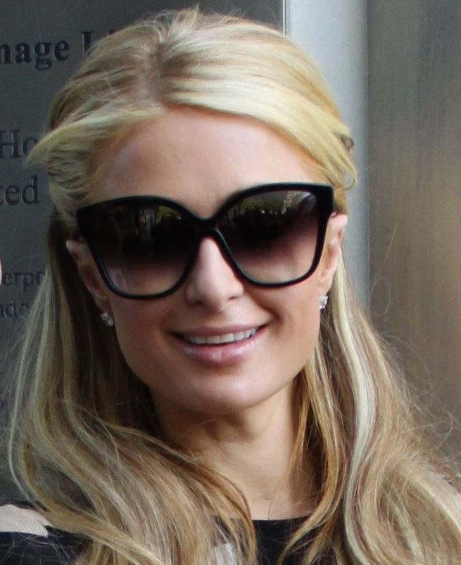 Paris Hilton mit langen, glatten blonden Haaren und sehr großer Sonnenbrille