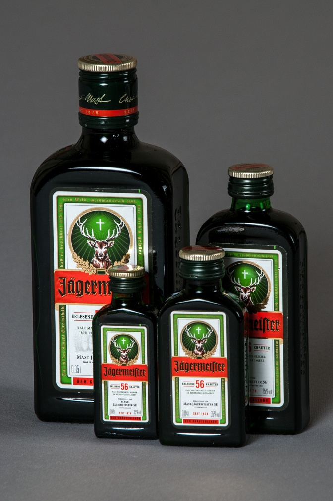 4 verschieden große Schnapsflaschen mit dem Markennamen Jägermeister und einem Logo mit Hirschgeweih