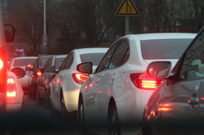 Mehrere Autos mit aufleuchtenden Bremslichtern stehen dicht hintereinander.