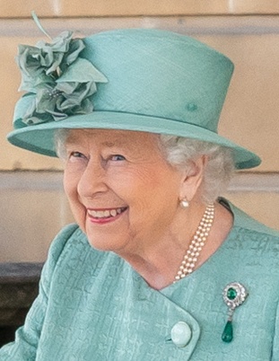 Queen Elisabeth in farblich aufeinander abgestimmtem Kostüm mit Hut.
