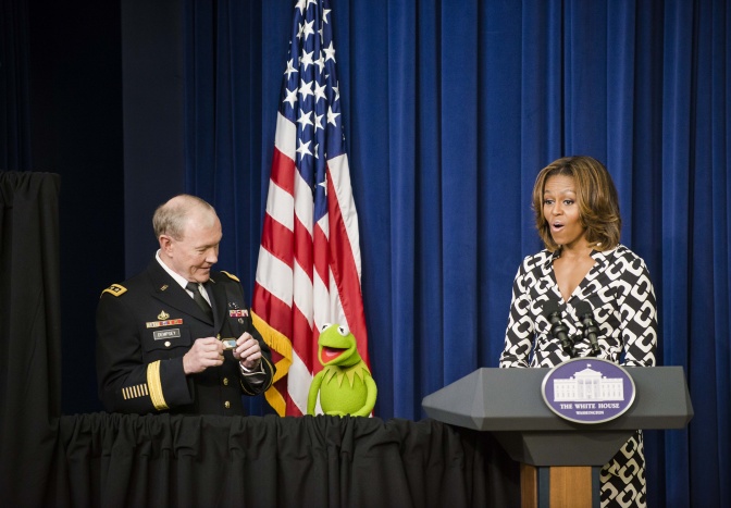 Kermit der Frosch mit Michelle Obama. Beide stehen vor einem blauen Vorhang und der amerikanischen Flagge.