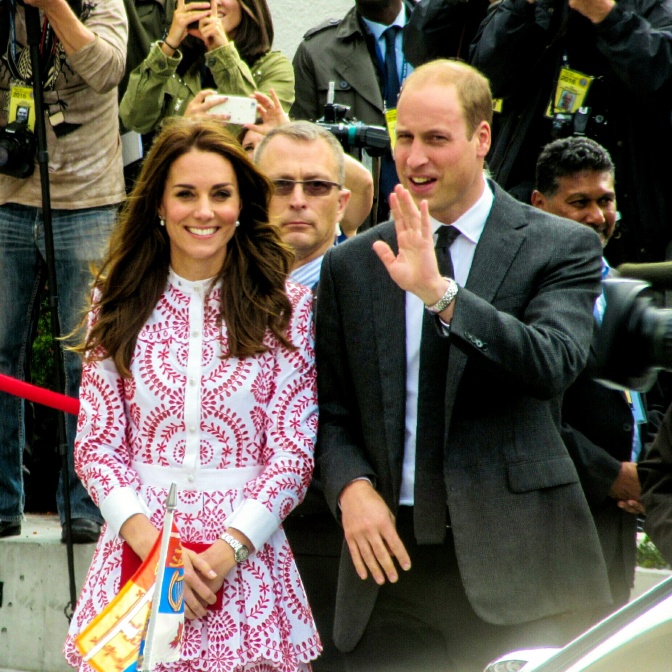 Prinz William und Herzogin Kate zwischen vielen Menschen. Prinz William winkt.